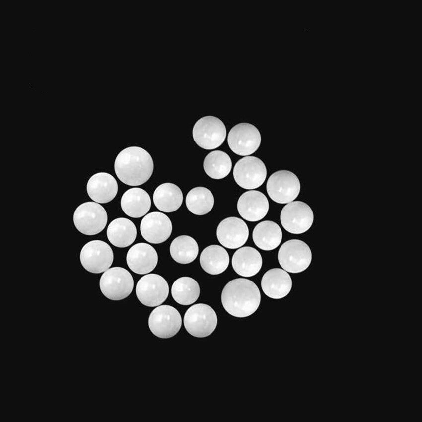 Ceramic balls arranged by size from 1.5mm to 16mm on a precision scale