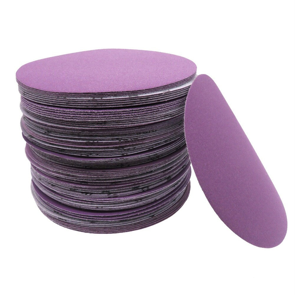 Multiple packs of purple sandpaper discs, showcasing the quantity per pack.