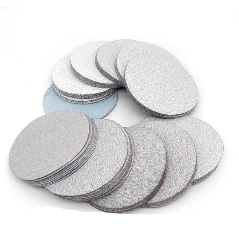 Assortment of 100mm round dry sanding pads in grits from P60 to P1000, neatly organized in a clear plastic storage box for DIY projects.