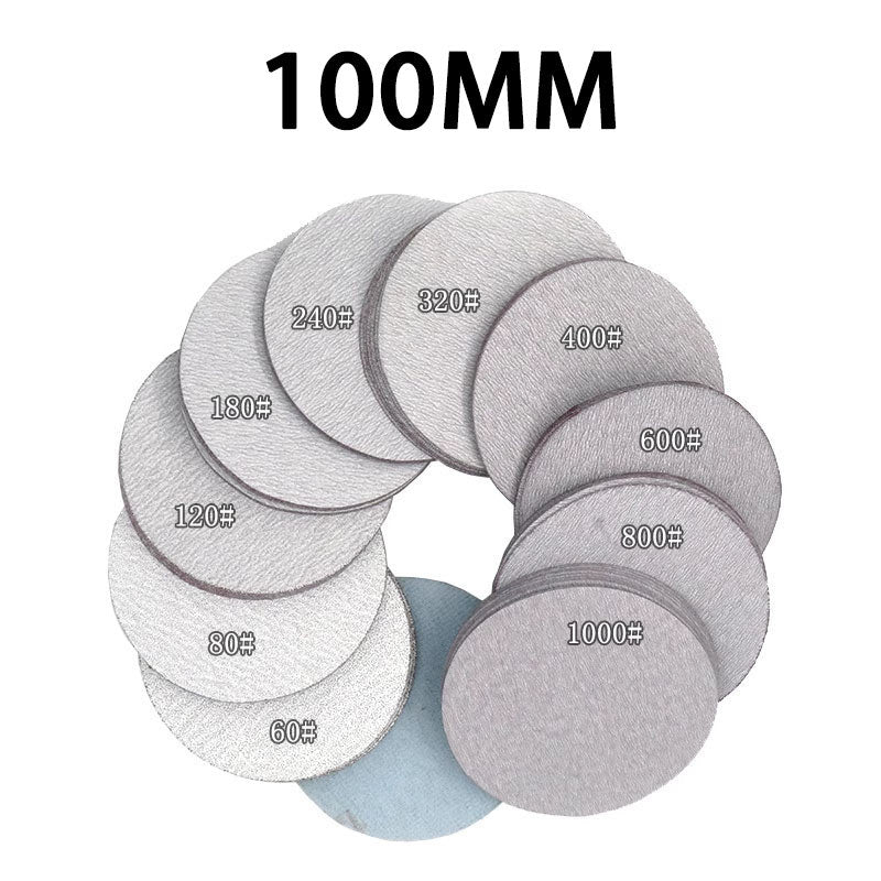 Close-up of the back of a 100mm dry sanding pad, showing the central mounting hole and ventilation holes for dust extraction.