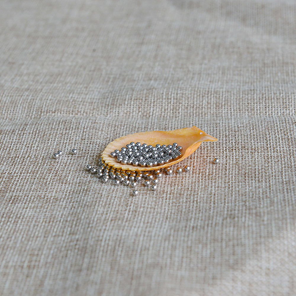 Close-up of a carbon steel ball being punched into a sheet metal component
