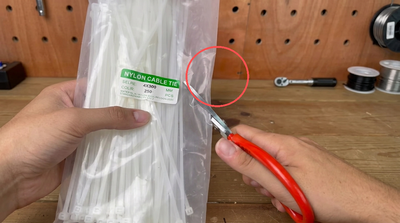 Clever slit-opening method for a nylon cable tie bag in a workshop setting
