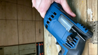 16:9 cover shot of blue power drill with homemade hot glue chuck key holder on wooden workbench, finished DIY tool hack, no text or overlays | HomeDIYer