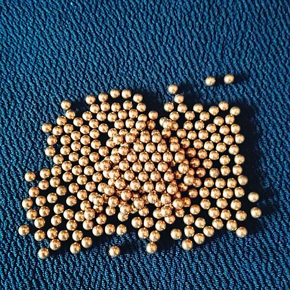 Size comparison of brass balls on a ruler highlighting the wide range