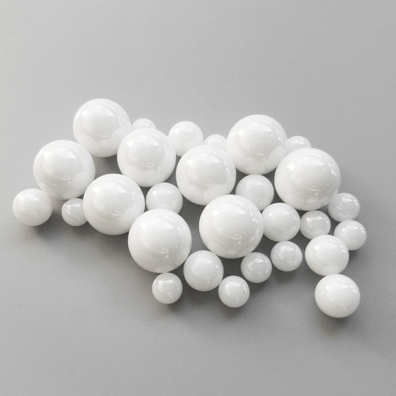 Assortment of white zirconia ceramic balls showing larger diameter sizes from 11mm to 15.87mm