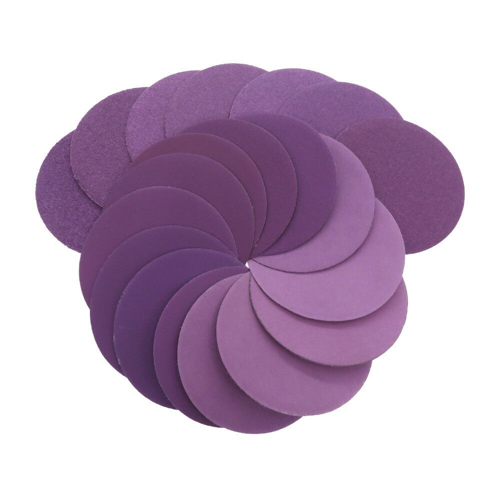 Stack of purple 75mm sanding discs showing their thickness and backing.