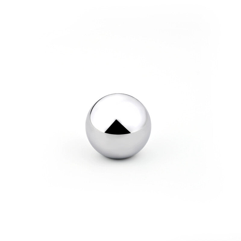 Size comparison of stainless steel beads on a heat-resistant surface