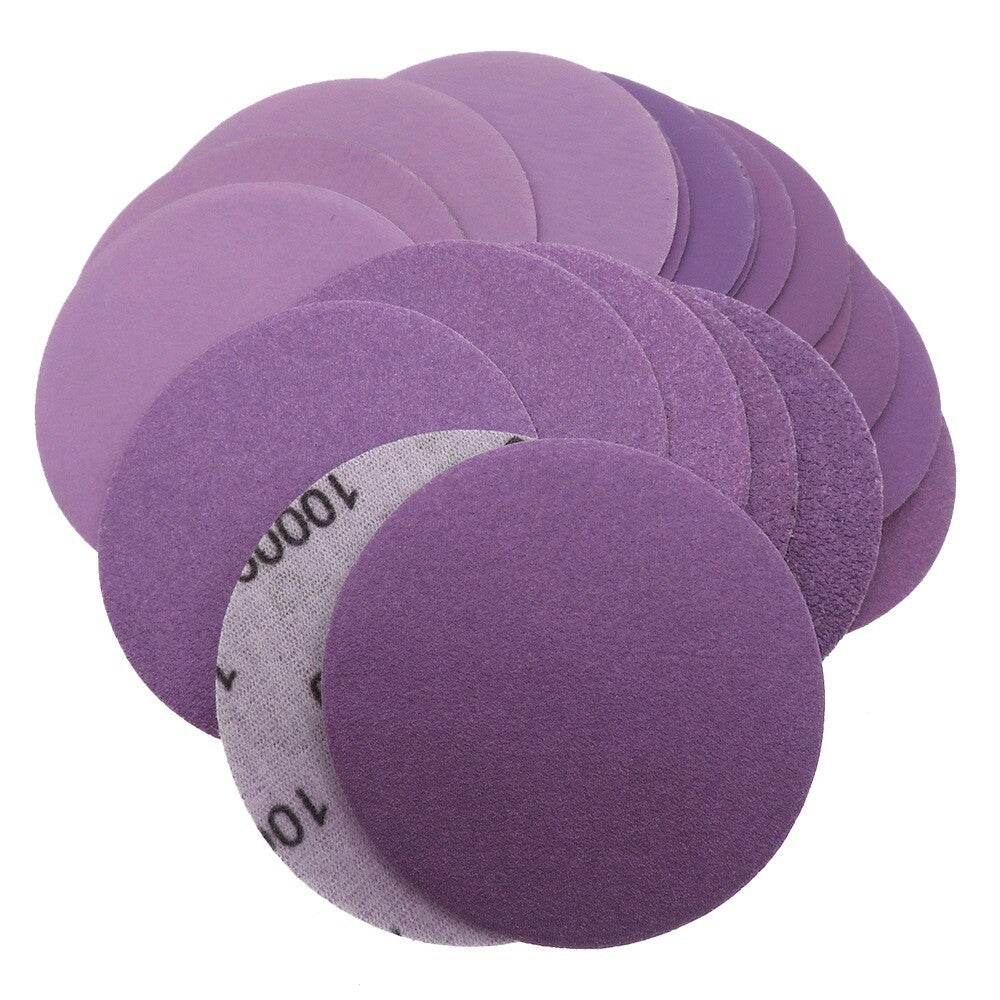Assortment of purple sanding discs with different grits from coarse to very fine.