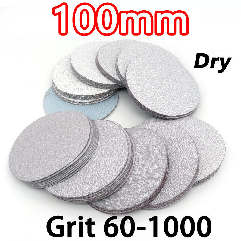 Assortment of 100mm round dry sanding pads in grits from P60 to P1000, neatly organized in a clear plastic storage box for DIY projects.