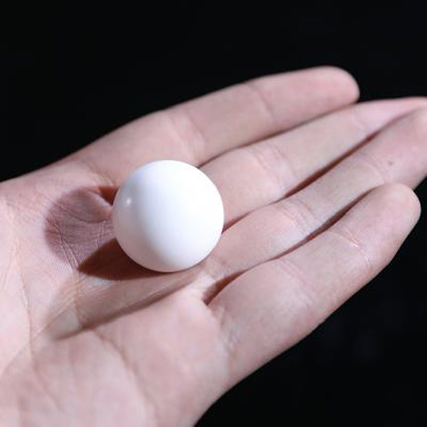 Multiple white PTFE spheres (3-63mm) displayed, industrial-grade for valve seal use